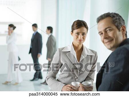 Business colleagues having coffee break in lobby View Large Photo Image Stock Photography - Business colleagues having coffee break in lobby. Fotosearch