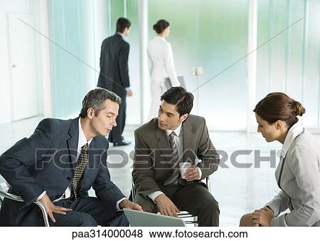 Stock Photo - Business people sitting in lobby, having discussion. Fotosearch