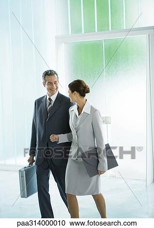 Businessman and businesswoman walking through lobby View Large Photo Image Stock Image - Businessman and businesswoman walking through lobby. Fotosearch