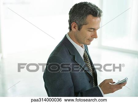 Businessman dialing cell phone View Large Photo Image Stock Photograph - Businessman dialing cell phone. Fotosearch
