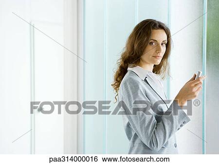 Stock Photograph - Businesswoman holding cell phone. Fotosearch
