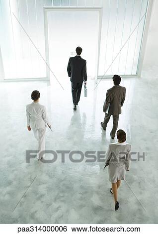 Stock Photograph - Four executives walking across lobby toward exit. Fotosearch