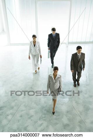 Stock Photo - Four executives walking through office building lobby. Fotosearch