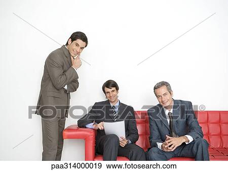 Stock Photo - Three businessmen in office lobby. Fotosearch