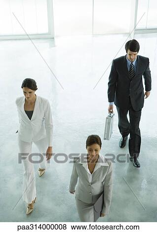 Stock Photo - Three executives entering office building lobby. Fotosearch
