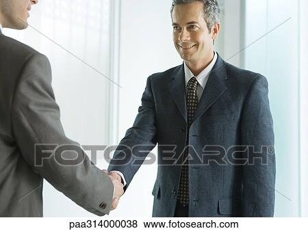 Stock Photo - Two businessmen shaking hands. Fotosearch
