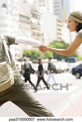 Young couple holding hands, running across street View Large Photo Image Stock Photo - Young couple holding hands, running across street. Fotosearch