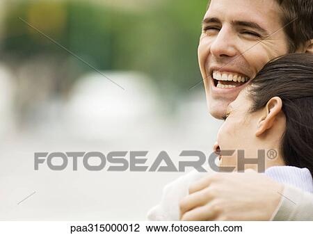 Young couple laughing, woman resting head on man's shoulder View Large Photo Image Stock Image - Young couple laughing, woman resting head on man's shoulder. Fotosearch