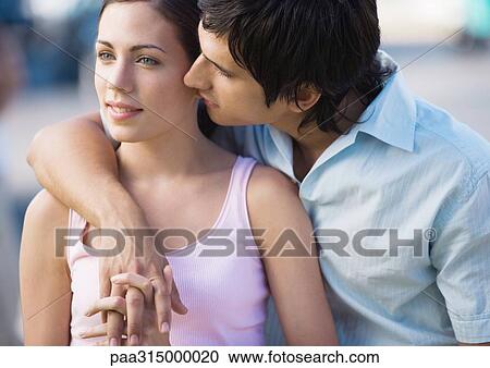 Young couple, man leaning over woman's shoulder View Large Photo Image Stock Image - Young couple, man leaning over woman's shoulder. Fotosearch