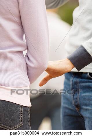 Young couple, man reaching for woman's arm View Large Photo Image Picture - Young couple, man reaching for woman's arm. Fotosearch