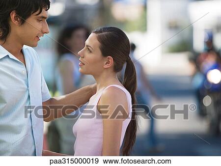 Young couple talking to each other in urban environment View Large Photo Image Stock Photo - Young couple talking to each other in urban environment. Fotosearch