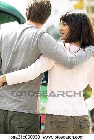 Young couple with arms around each other View Large Photo Image Stock Image - Young couple with arms around each other. Fotosearch