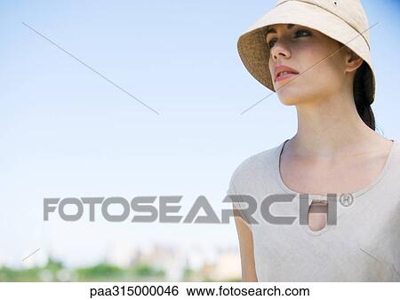 Stock Photograph - Young woman wearing sun hat. Fotosearch