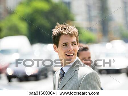 Businessman in street, looking over shoulder View Large Photo Image Stock Image - Businessman in street, looking over shoulder. Fotosearch