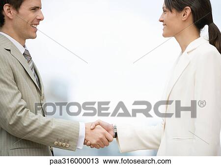 Stock Image - Businesswoman and man shaking hands. Fotosearch