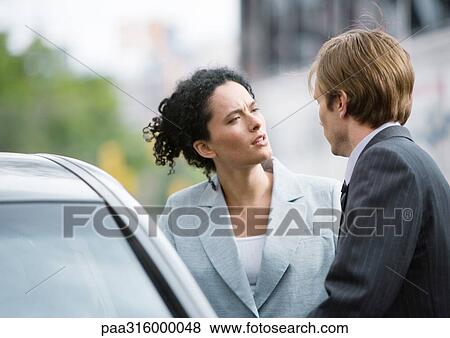 Businesswoman and man speaking next to car View Large Photo Image Stock Photo - Businesswoman and man speaking next to car. Fotosearch