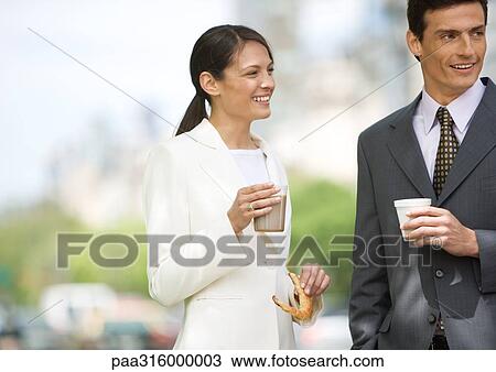Businesswoman and man standing, having coffee outdoors View Large Photo Image Stock Image - Businesswoman and man standing, having coffee outdoors. Fotosearch