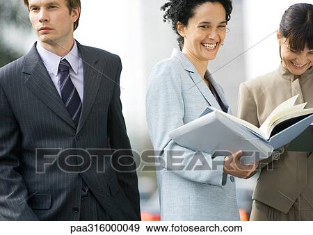 Businesswoman laughing, businessman walking by View Large Photo Image Stock Photo - Businesswoman laughing, businessman walking by. Fotosearch
