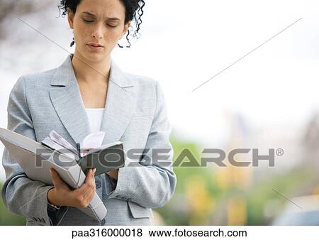 Businesswoman looking down at agenda View Large Photo Image Stock Photo - Businesswoman looking down at agenda. Fotosearch