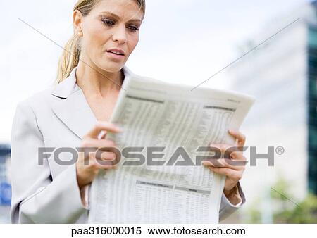 Businesswoman reading financial pages of newspaper View Large Photo Image Stock Photography - Businesswoman reading financial pages of newspaper. Fotosearch