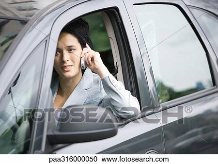 Businesswoman using cell phone in car View Large Photo Image Stock Image - Businesswoman using cell phone in car. Fotosearch