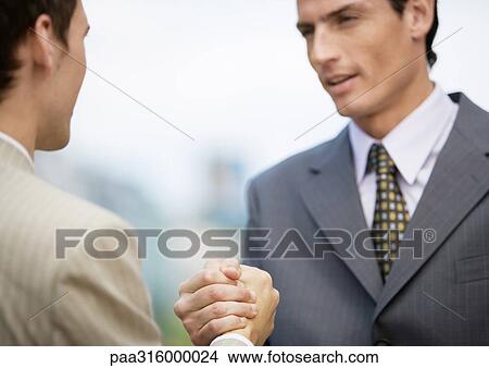 Two businessmen gripping hands View Large Photo Image Picture - Two businessmen gripping hands. Fotosearch