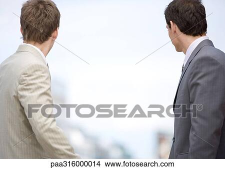Two businessmen looking into the distance, rear view View Large Photo Image Picture - Two businessmen looking into the distance, rear view. Fotosearch
