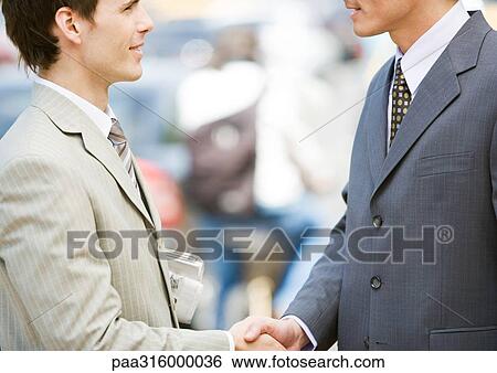 Stock Photograph - Two businessmen shaking hands. Fotosearch