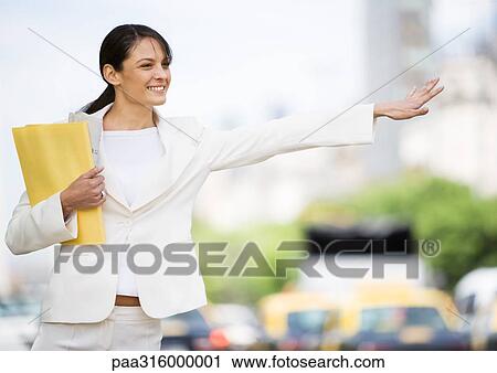 Young businesswoman hailing taxi View Large Photo Image Stock Image - Young businesswoman hailing taxi. Fotosearch