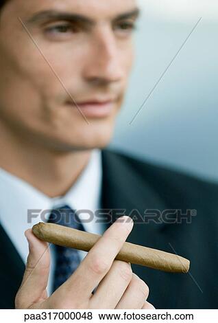Businessman holding cigar View Large Photo Image Stock Photo - Businessman holding cigar. Fotosearch