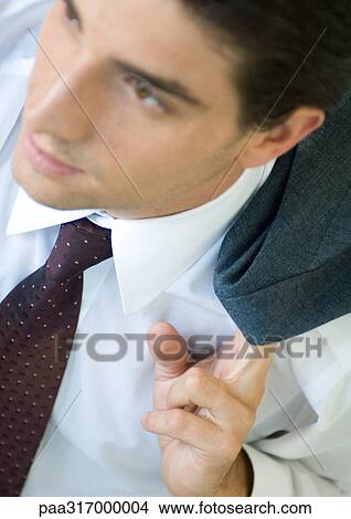 Businessman holding coat over shoulder View Large Photo Image Picture - Businessman holding coat over shoulder. Fotosearch