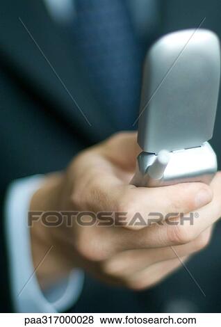 Businessman's hand holding flip phone View Large Photo Image Stock Photo - Businessman's hand holding flip phone. Fotosearch