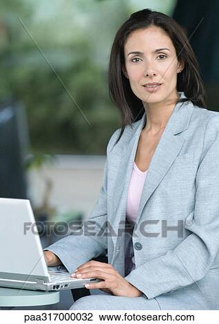 Stock Image - Businesswoman sitting with laptop. Fotosearch