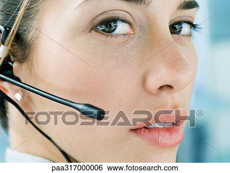 Stock Photograph - Woman wearing headset, close-up. Fotosearch