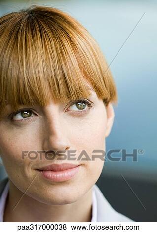Stock Photo - Woman with bangs looking up, portrait. Fotosearch