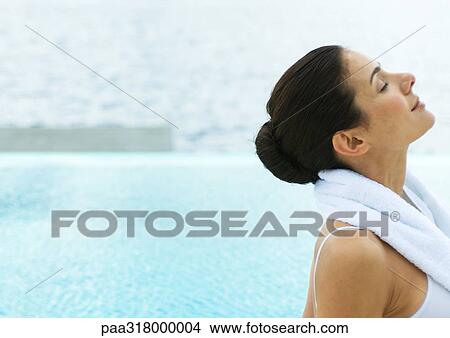Woman by edge of water with head back and eyes closed View Large Photo Image Picture - Woman by edge of water with head back and eyes closed. Fotosearch