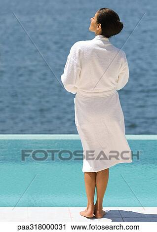 Woman in bathrobe standing near pool overlooking sea, rear view View Large Photo Image Stock Image - Woman in bathrobe standing near pool overlooking sea, rear view. Fotosearch