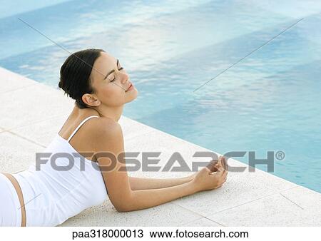 Woman lying on ground by edge of pool, eyes closed View Large Photo Image Stock Image - Woman lying on ground by edge of pool, eyes closed. Fotosearch
