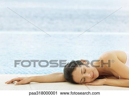 Woman napping on ground at edge of water View Large Photo Image Stock Image - Woman napping on ground at edge of water. Fotosearch