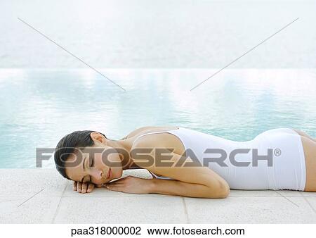 Woman napping on ground at edge of water View Large Photo Image Stock Image - Woman napping on ground at edge of water. Fotosearch