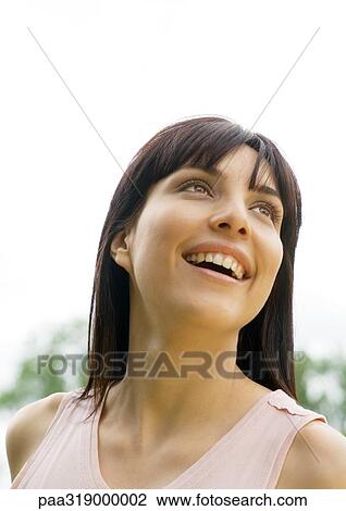 Woman smiling and looking up, portrait View Large Photo Image Stock Image - Woman smiling and looking up, portrait. Fotosearch