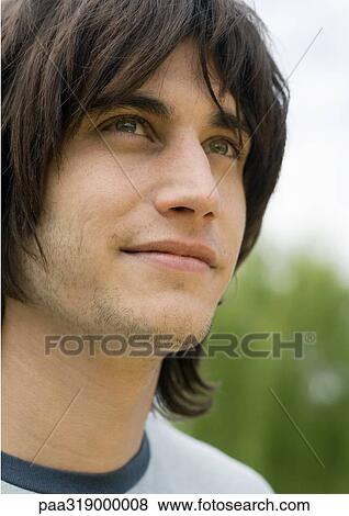 Stock Photo - Young man looking up, portrait. Fotosearch