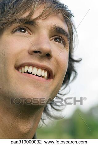 Stock Image - Young man smiling, portrait. Fotosearch