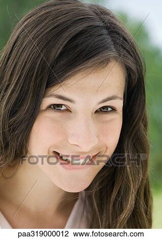 Young woman biting lip, portrait View Large Photo Image Stock Image - Young woman biting lip, portrait. Fotosearch