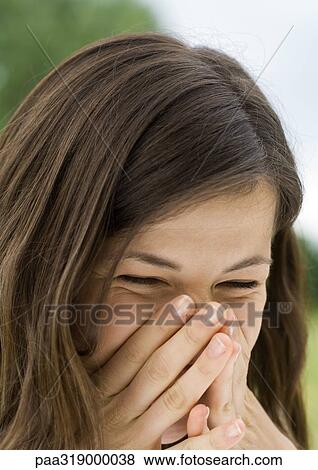 Young woman laughing and covering face with hands View Large Photo Image Stock Photo - Young woman laughing and covering face with hands. Fotosearch