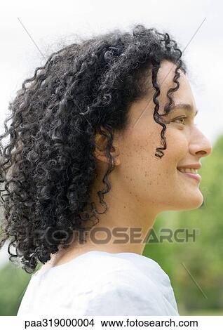 Young woman smiling, side view, portrait View Large Photo Image Picture - Young woman smiling, side view, portrait. Fotosearch