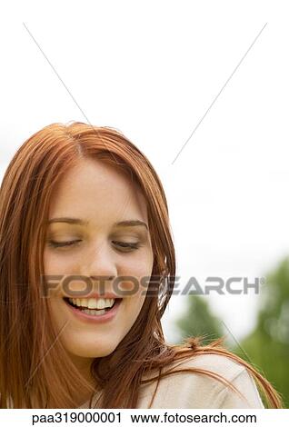 Young woman smiling with eyes lowered, portrait View Large Photo Image Stock Image - Young woman smiling with eyes lowered, portrait. Fotosearch