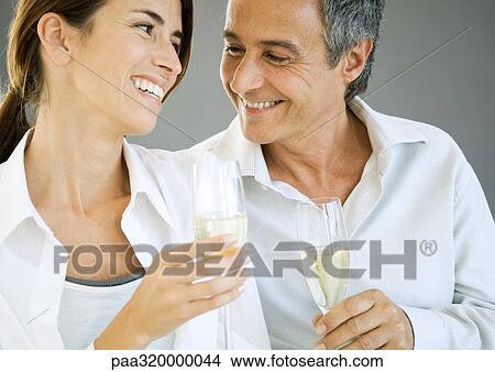 Couple holding champagne flutes View Large Photo Image Picture - Couple holding champagne flutes. Fotosearch