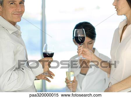 Stock Photography - Mature group of friends drinking wine. Fotosearch