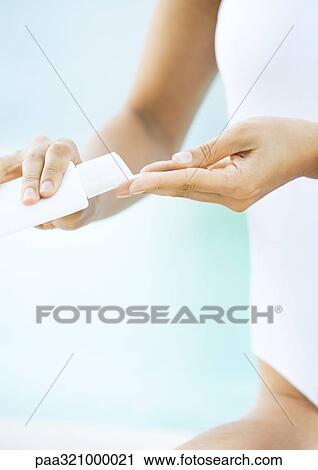 Stock Image - Woman applying sunscreen. Fotosearch